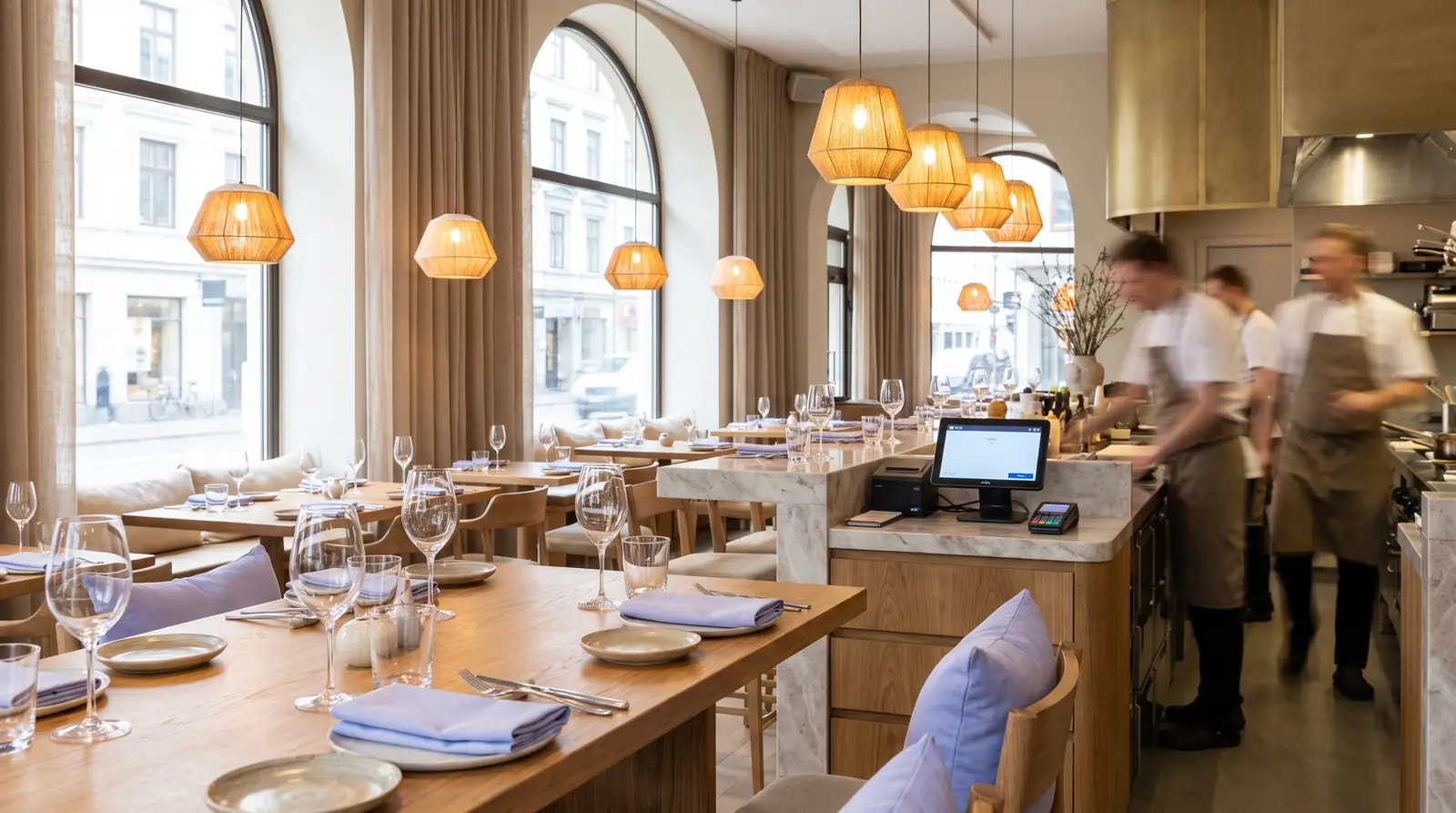 Interior de restaurante con las mesas puestas y la barra con el terminal de cobro, antes de abrir
