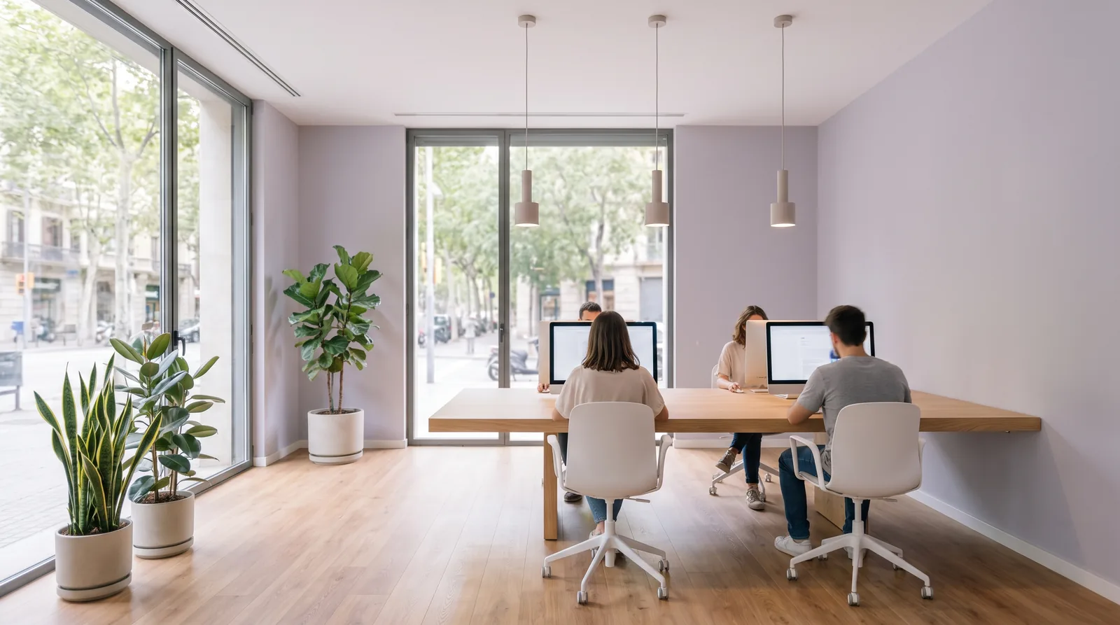 Equipo de atención al cliente trabajando con ordenadores en una oficina luminosa